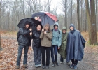 wolontariusze podczas pieszej pielgrzymki w lesie, pada deszcz
